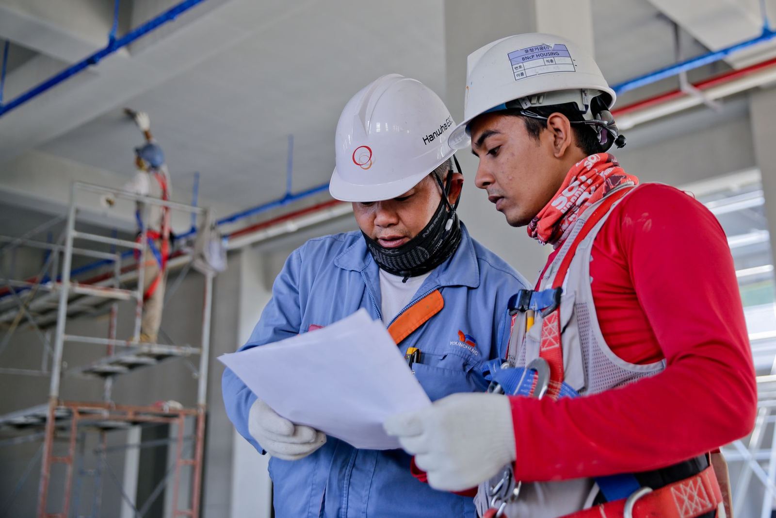 Two workers reading a site document on a construction project